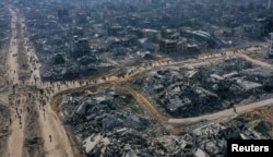 A drone view shows displaced Palestinians walking past the rubble as they attempt to return to their homes, amid a ceasefire between Israel and Hamas, in the northern Gaza Strip, Jan. 19, 2025.